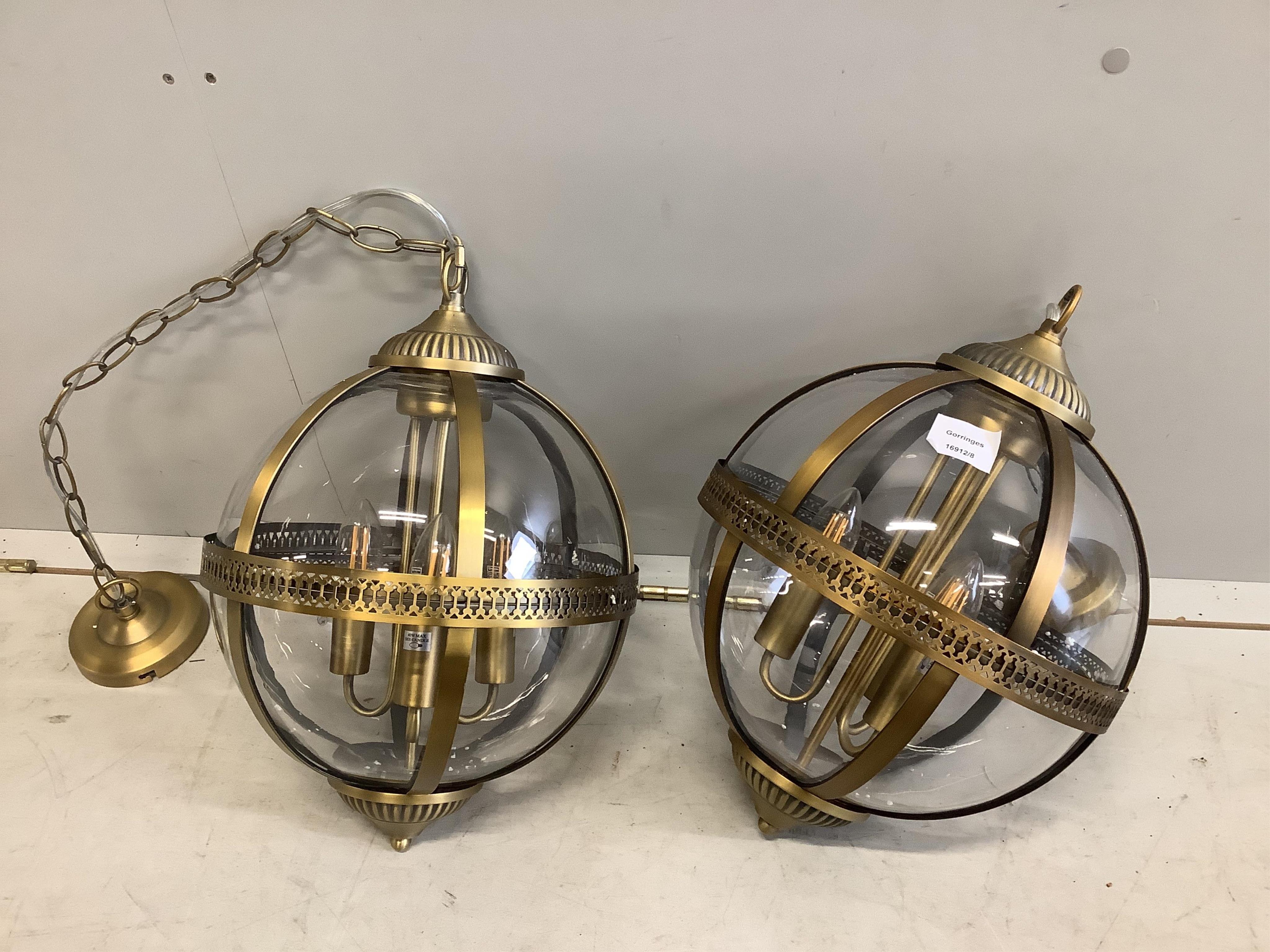 A pair of Contemporary gilt metal globe hall lanterns, height 36cm. Condition - good